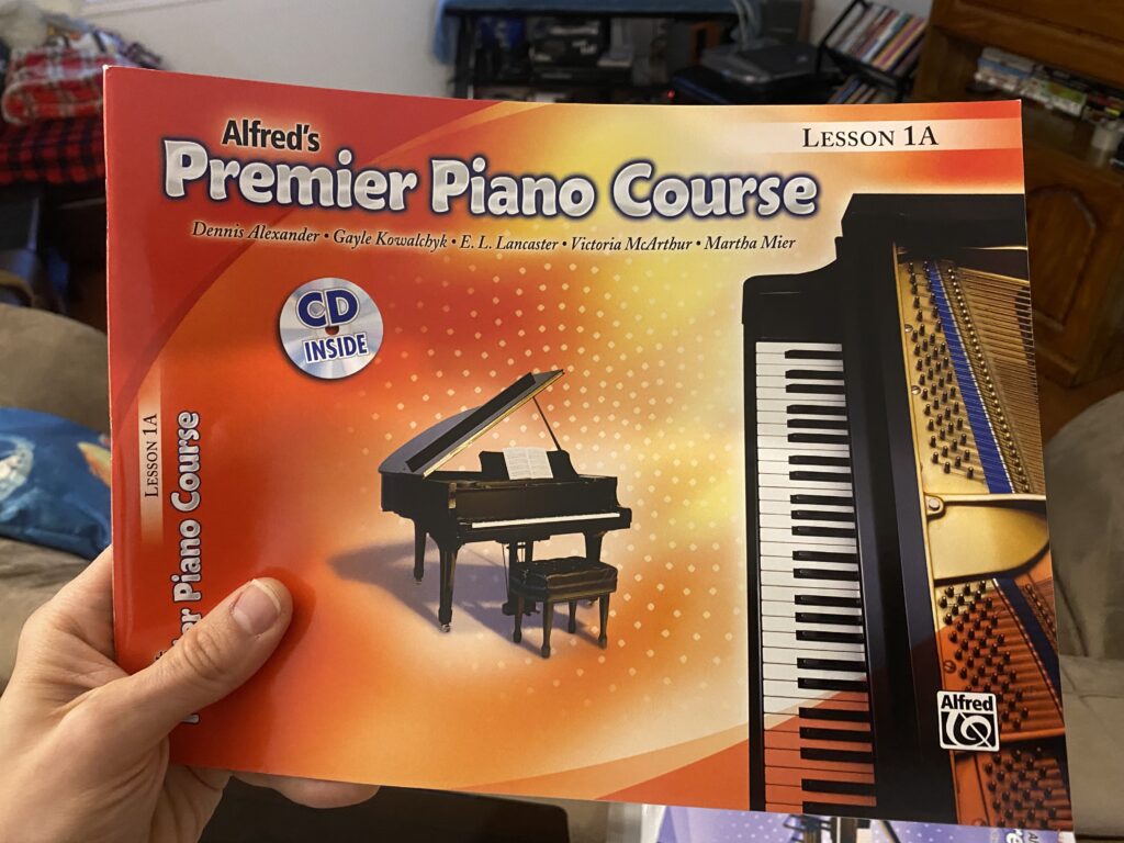 Alfred Premier Piano Book 1A Being Held up in the Kelowna home music studio of Upnotes Music